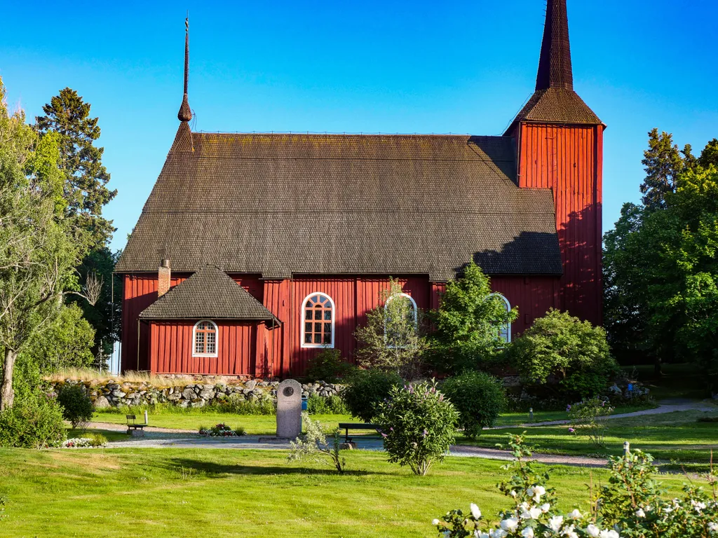 Eine rote Kirche mit schwartem Dach aus Holz 