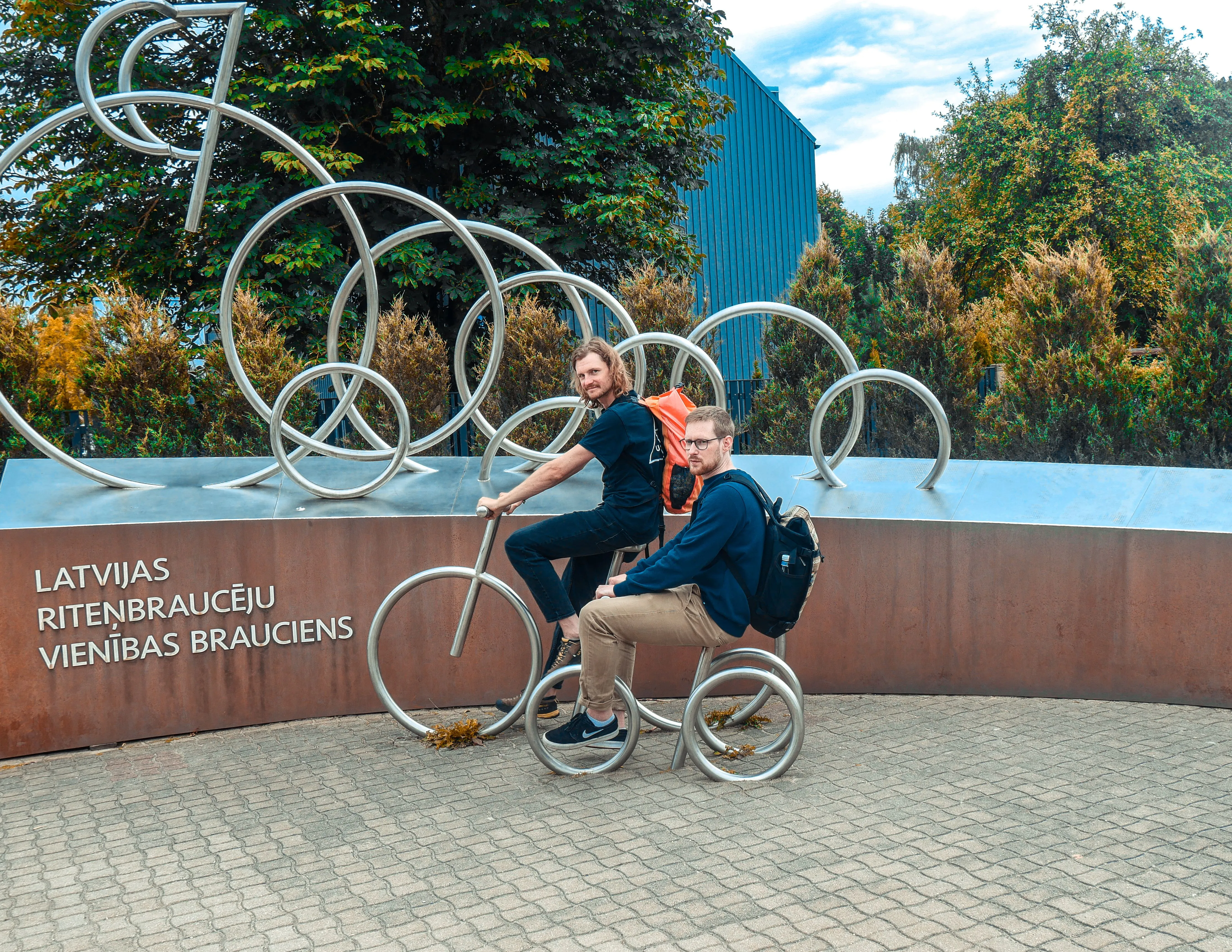 Ich sitze mit eine Freund auf Kunstfahrradärn welche als Skulptur aufgestellt wurden und wir grinsen in die Kamera.