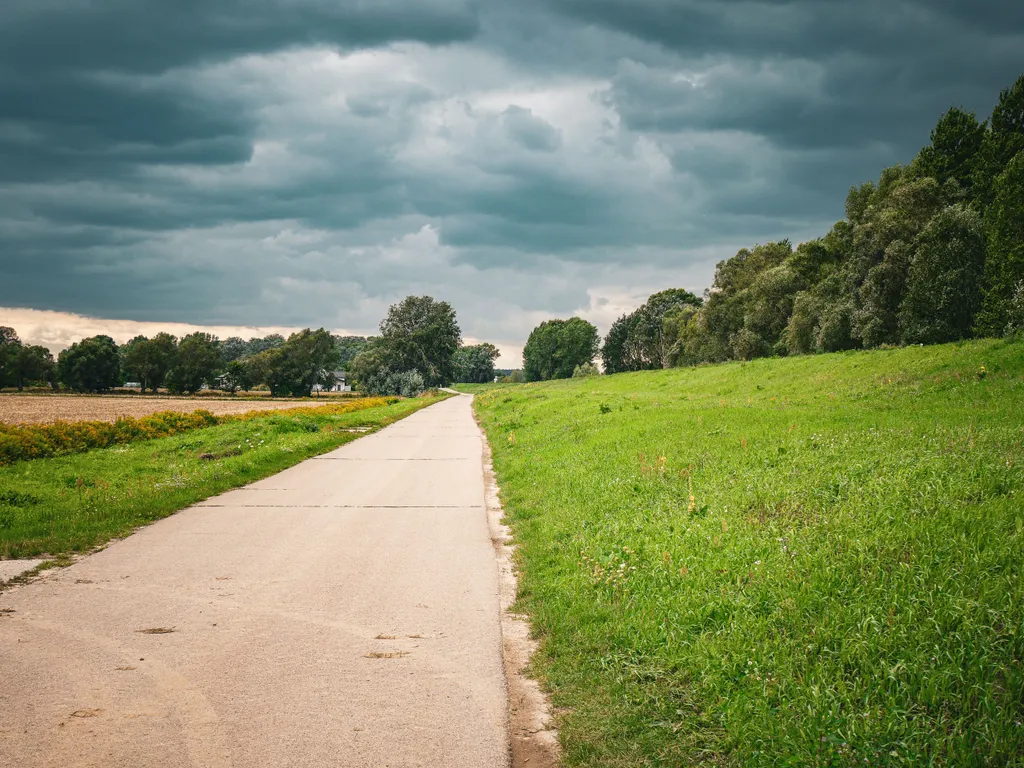 Eine Teerstraße führt in Richtung dunkler Wolken