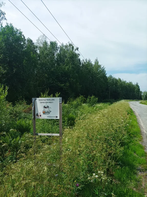 Schild am Straßenrand "Free Coffee for Bicycle Travellers"