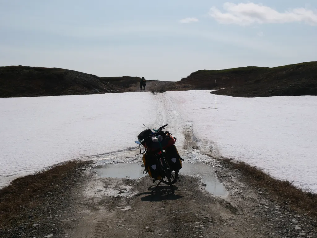 Mein Fahrrad steht auf dem Kiesweg vor einer schneebedeckten Passage.